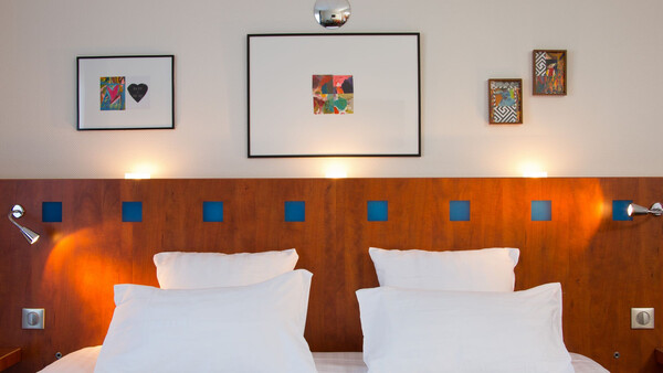 Vue sur un lit dans une chambre de l'hôtel Pariou avec piscine, parfait pour les vacances en Auvergne